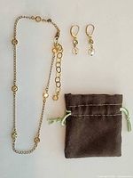 Full view of necklace, earrings pair, and pouch