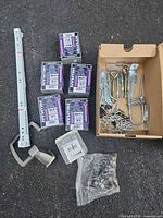 Full lot layout showing boxes of screws, rail, brace, cardboard box of hardware, bag of small fasteners