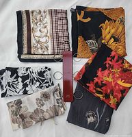 Overview of all scarves folded and wooden hanger