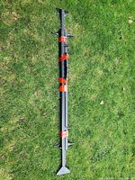 Full length view of bundled metal bed frame components on grass