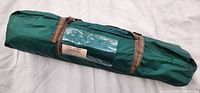 Closed green zippered carry bag holding tent