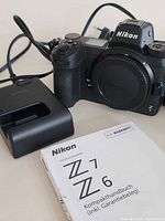 Front view of Nikon Z6 body with body cap, charger, USB cable and German manual