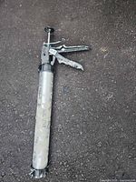Full view of the Pro Gun caulking gun on pavement