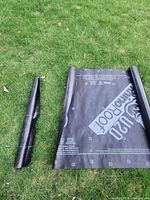 RhinoRoof U20 underlayment roll next to weed barrier roll on grass
