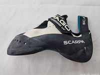 Left side profile of single shoe showing Scarpa logo, DRAGO LV strap, aggressive downturn