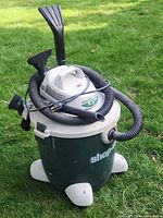 Full view of vacuum with hose and attachments wrapped around