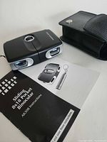 Binocular with case and manual on table