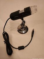 Side view showing Veho branding, stand and USB cable