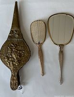 Front view of brass bellows, mirror, brush