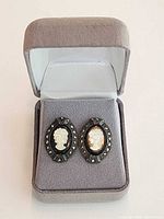 Earrings displayed in open grey presentation box