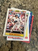 Stack of mixed baseball cards, top card 1989 Topps Rookies Bob Geren visible