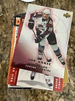 Stack of hockey trading cards, top card Joe Sakic Upper Deck