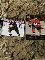 Two Brady Tkachuk hockey trading cards displayed on countertop