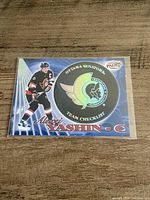 Front view of the Alexei Yashin 1998-99 Pacific Team Checklist hockey card in sleeve on wooden surface