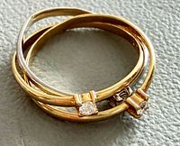 Interlocking ring showing gold and silver bands with stones