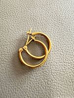 Hoop earrings closed view on textured surface