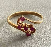 Full view of gold ring showing ruby arrangement