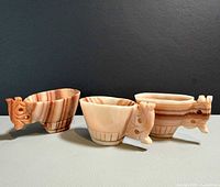 Three carved stone cups front view