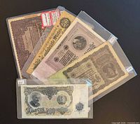 Group shot of four banknotes in sleeves
