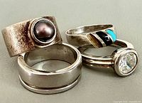 Group shot of four sterling silver rings showing design variety