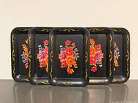 five of six trays upright showing floral design and border