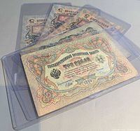 Stack of plastic-sleeved 1909 Russian banknotes, 3-ruble note on top