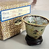 Planter on stand beside original patterned box showing label