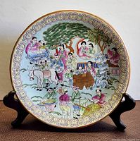 Front view of porcelain platter on stand showing full decorative scene