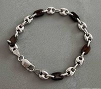 Full view of bracelet showing alternating silver and dark brown links and lobster clasp