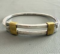 Side view of bangle showing silver bars and brass sleeves