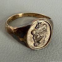 Ring angled view showing Victorian woman relief and gold tone
