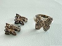 Ring and pair of earrings displayed on surface