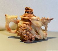 Front view of carved Shoushan stone teapot showing dragon relief and handle