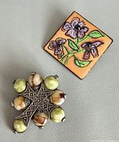 Both brooches side by side for size and style comparison