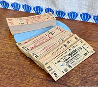 Full stack of buff cardstock ticket stubs displayed on wood surface