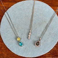 Three sterling silver pendant necklaces laid flat