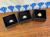 Group shot of three sterling silver rings in boxes