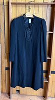 Full frontal view of black dress on hanger
