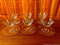 Six etched crystal coupes on wooden surface