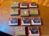 All eleven Omega chalk boxes arranged on table
