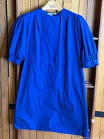 Front view of blue Christian Dior Sport dress hung on hanger
