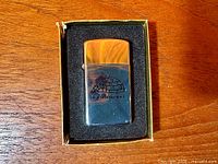 Front view of chrome Zippo lighter in box base showing igloo motif and text