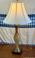 Full view of Murano glass table lamp with shade illuminated