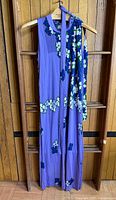 Front view of full dress on hanger showing print, pleats and length