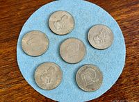Six Eisenhower dollars on blue felt showing reverse