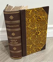 Spine and boards showing leather binding, gilt lettering and marbled paper