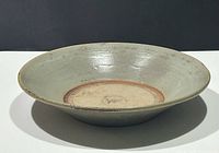 Top view of grey-green celadon stoneware dish showing glaze, central unglazed band and profile