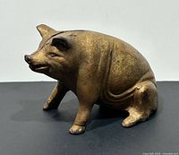 Left side view of cast iron seated pig bank