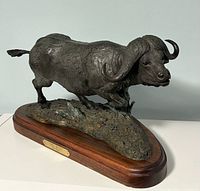 Full left-side view of bronze Cape Buffalo on hardwood base