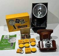 Group image showing camera, case, flash unit, flash box, manual, filter boxes, adapter ring and filter case